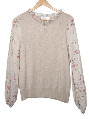 Sioni Milano beige blouse featuring sheer floral sleeves and a ruffled neckline